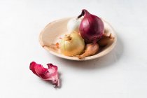 Cipolle varie su un piatto di legno — Foto stock