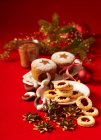 Various christmas biscuits on red surface with decorations — Stock Photo