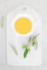 Frischer grüner Tee in einem weißen Teller auf hellem Hintergrund — Stockfoto