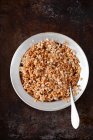 Porridge di grano saraceno con un cucchiaio e una ciotola di avena su uno sfondo scuro. vista dall'alto. — Foto stock