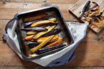Roasted heritage carrots with lemon and cumin in a baking tray — Stock Photo