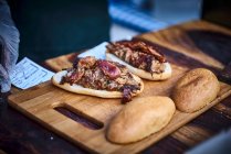 Cordeiro em um pão em uma tábua de madeira em uma cozinha de rua — Fotografia de Stock