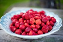 Fresh wild strawberries on vintage plate — Stock Photo