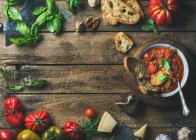 Hausgemachte italienische geröstete Tomaten- und Knoblauchsuppe in Schüssel mit Basilikum und Parmesan — Stockfoto