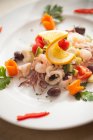 Seafood salad with squid, prawns, courgettes, olives and cherry tomatoes — Stock Photo