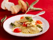 Porcini mushroom ravioli with sage butter and cherry tomatoes — Stock Photo