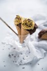 Chocolate cake topped with caramel cream and dark chocolate sprinkles served in ice cream cones (vegan) — Stock Photo