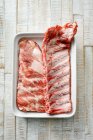 Costolette di maiale crude con spezie su una tavola di legno — Foto stock