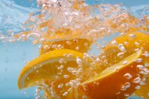 Оранжевые ломтики в газированной воде — стоковое фото