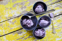 Várias tigelas de sorvete de mirtilo em um fundo de madeira — Fotografia de Stock