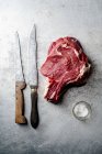 Raw beef steak with a knife and pinch of salt — Stock Photo