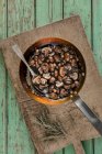 Brown mushrooms glazed in butter marsala wine and thyme in rustic frying pan with spoon on wooden chopping board — Stock Photo