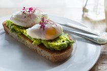 Пашотні яйця з авокадо і цитроном на тарілці — стокове фото