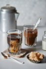 Café helado en un vaso con crema y terrones de azúcar morena - foto de stock