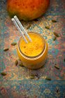 Eine Mango-Lassi im Glas mit einem Strohhalm — Stockfoto