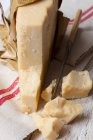 Stück Parmesan auf rustikalem Tuch mit kleinem Messer — Stockfoto
