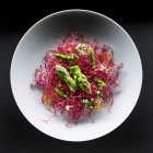 Green asparagus tips with beetroot sprouts — Stock Photo