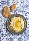 Hummus with olive oil and flatbread on ornate tiles — Stock Photo