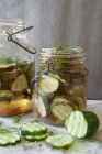 Pepinos de decapado en rodajas marinando en tarros de vidrio vintage - foto de stock