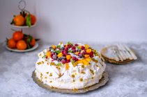 Pavlova-Kuchen mit gefrorenen Beeren und Kokosnuss auf einem Blech — Stockfoto
