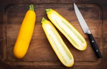 Two yellow courgettes, one whole and one halved — Stock Photo