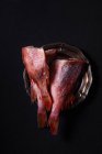 Poleiro de peixe cru congelado não cozido sobre fundo preto — Fotografia de Stock