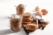 Mini chocolate cakes baked in jars with ingredients — Stock Photo