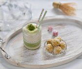 Vegan matcha latte with mango and coconut balls on a tray — Foto stock