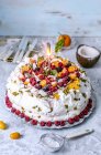 Pavlova cake with frozen berries and coconut — Stock Photo