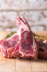 Rohe Rindfleischkoteletts auf einem Holztisch — Stockfoto