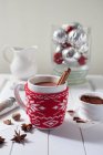 Cacao chaud avec bâtonnets de cannelle dans une tasse de vacances — Photo de stock