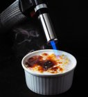Primo piano di una padella per friggere con un cucchiaio di un bollitore nero su uno sfondo scuro — Foto stock