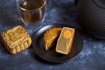 Moon cake from China with a baked egg yolk, served with tea — Stock Photo