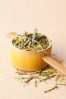 Japanese green tea leaves in a wooden measuring spoon — Photo de stock