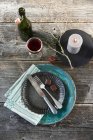 A vintage place setting with two chocolate covered marzipan and gingerbread sweets, a candle and red wine - foto de stock