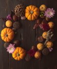 Fond d'automne avec citrouilles, cônes et citrouille sur table en bois — Photo de stock