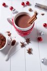 Chocolate caliente con palitos de canela en una taza de Navidad - foto de stock