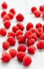 Close-up shot of delicious Raspberries on white surface — Stock Photo