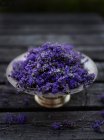 Fresh lavender flowers in a silver bowl on a wooden surface — Stock Photo