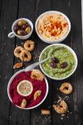 Hummus, spinach hummus and beetroot hummus with sesame seed bread rings — Stock Photo