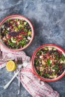 Kale, pomegranate and feta cheese tabbouleh in two bowls with spring onions and lemon mint dressing — Stock Photo