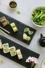 Various types of sushi with edamame beans in bowl — Stock Photo