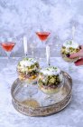 Салат в стеклянных чашках на серебряном подносе и коктейли в честь Нового года — стоковое фото