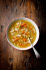 Суп с курицей и овощами на деревянном фоне — стоковое фото