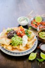 Mexican nachos with guacamole sour cream and pico de gallo — Stock Photo