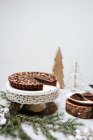 Gâteaux au chocolat sur un stand de gâteau sur une table décorée pour Noël — Photo de stock