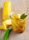 Gelbe eingelegte Zucchini mit Lorbeerblättern, Senf, Essig und Zucker im Glas — Stockfoto