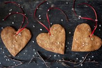 Biscoitos de gengibre de Natal em forma de coração com fitas decorativas — Fotografia de Stock