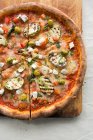 Pizza à la feta et aux légumes sur une planche de bois — Photo de stock