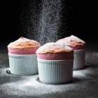 Muffins caseiros com açúcar em pó e chocolate em um fundo preto. — Fotografia de Stock